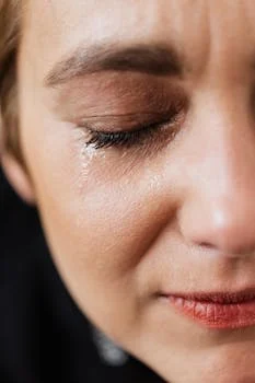 Rosto parcial de uma mulher com aparência de choro e angústia, e ansiedade.,